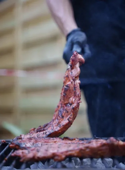 A YPA grill master tending the charcoal fire
