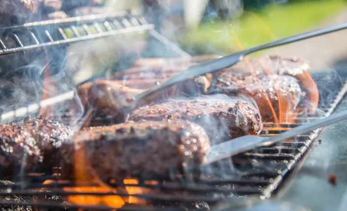 Goat meat slow-grilling over open charcoal