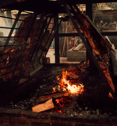 A whole goat grilling over open charcoal fire